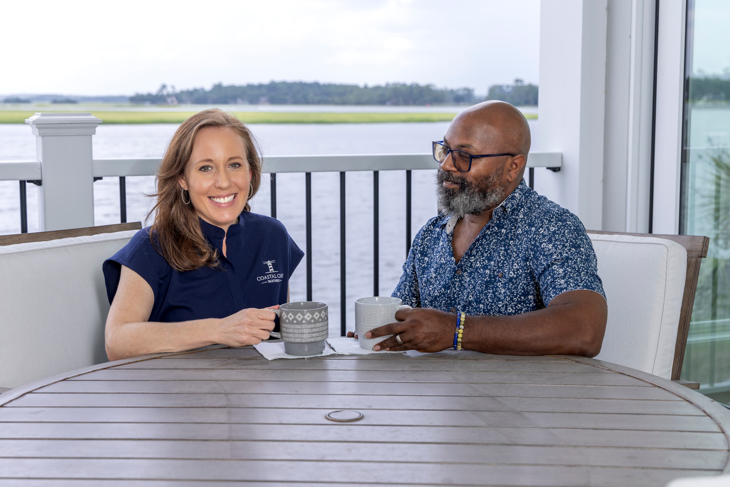 Caregiver and older adult sharing a calm moment on a porch